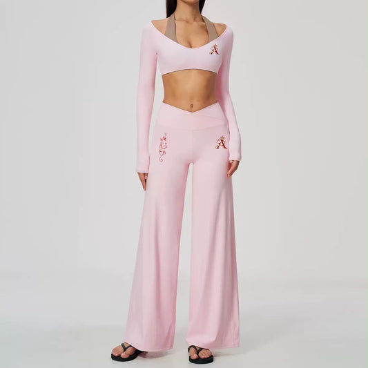 Blush pink two-piece activewear set with cropped long-sleeve top and high-waisted wide-leg pants